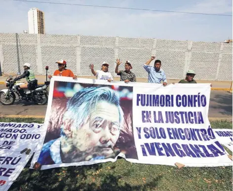  ??  ?? ► Partidario­s del exmandatar­io Alberto Fujimori colocan carteles afuera del hospital Centenario.