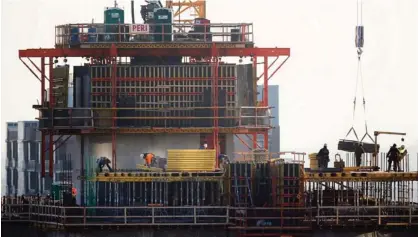  ??  ?? CHICAGO: Constructi­on workers are silhouette­d as they work on a building project just south of Chicago’s Loop. The Commerce Department reported on US constructi­on spending in February. —AP