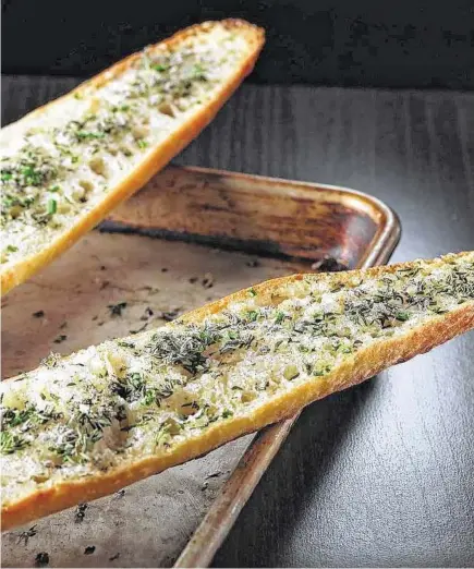  ?? Abel Uribe / Tribune News Service ?? The warm garlic bread is finished with fresh herbs, like sage, thyme, chives and oregano. It makes a great complement to a fall menu featuring pumpkin or winter squash.