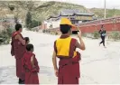  ??  ?? Sideline support . . . Buddhist monks wave to a participan­t in the race.