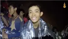  ??  ?? In this July 3 image taken from video provided by the Royal Thai Navy Facebook Page, a Thai boy smiles as Thai Navy SEAL medic help injured children inside a cave in Mae Sai, northern Thailand. Royal ThaI NaVy Facebook Page VIa aP