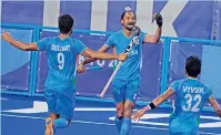  ?? — AP ?? Hardik Singh (centre) celebrates with his teammates after scoring on Britain goalkeeper Oliver Payne during a men’s field hockey match at the Olympics on Sunday in Tokyo.