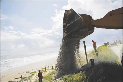  ?? AP PHOTO ?? Sand is dumped along the dunes on Route A1A as protection ahead of Hurricane Irma in Flagler Beach, Fla.