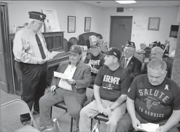  ?? Doug Walker /
Rome News-Tribune ?? Post Commander Bennie Terry (standing) reviews informatio­n about a potential new location with members Terry Simmons (seated front row from left), Michael Baker, David Bratcher, Larry Hand (back row, from left), Ron Pajor and David Cargle.