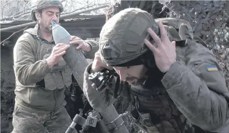  ?? ?? Militares de la 47ª brigada mecanizada de Ucrania se preparan para disparar un mortero en dirección a Avdiivka. EFE