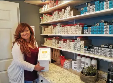  ?? DONNA ROVINS — DIGITAL FIRST MEDIA ?? Erin Tobin, the owner of Apothecary Hair Lounge in Limerick, displays a receptacle for collecting leftover hair color. It’s one of the items the salon recycles as a Green Circle Certified Salon. The salon also collects hair clippings and metals like...