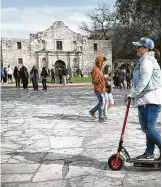  ?? Bob Owen / Staff photograph­er ?? A scooter rider zips through Alamo Plaza on Monday, though such vehicles, along with skateboard­s and bicycles, are now prohibited on the plaza, one of the first steps toward a full revamp.