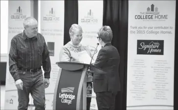  ?? Herald photo by Ian Martens ?? President Paula Burns recognizes home buyers Fred and Gail Barbero with a student award as part of an event for the College Home initiative Wednesday at Lethbridge College.