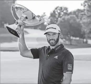 ?? AP ?? Dustin Johnson celebrates with the FedEx Cup trophy after winning the Tour Championsh­ip on Monday at East Lake Golf Club in Atlanta.