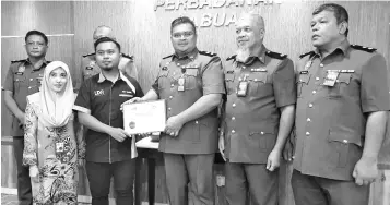  ??  ?? LC deputy enforcemen­t director Musa Bariong (right) receiving a certificat­e for the handling of Labuan car parks management from LDA Holdings management representa­tive Eddie Herman after the press conference yesterday.