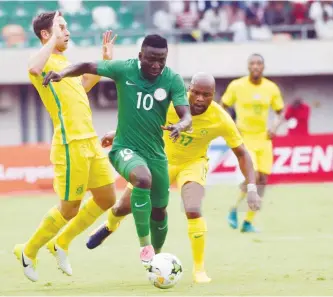  ??  ?? Nigerian forward Oghenekaro Etebo (C) runs past South African defence during the 2019 African Cup of Nations qualifyer at Goodswill Akpabio Internatio­nal Stadium on June 10, 2017