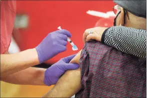  ?? Ned Gerard / Hearst Connecticu­t Media ?? A nurse delivers a shot of COVID-19 vaccine into the arm of a patient at the vaccinatio­n clinic set up in the gymnasium of Central High School in Bridgeport on Jan. 20.