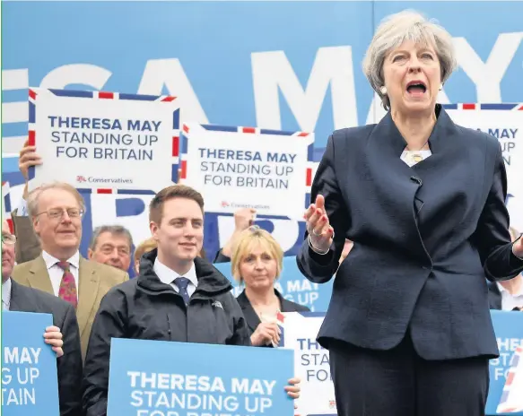  ??  ?? > Prime Minister Theresa May speaks to party supporters in front of the Conservati­ve party’s general election campaign battle bus at an airfield north of Newcastle yesterday