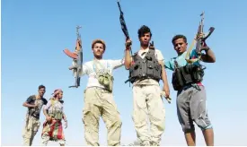  ??  ?? DABAB, Yemen: Armed Yemeni tribesmen from the Popular Resistance Committees, supporting forces loyal to Yemen’s Saudi-backed President Abedrabbo Mansour Hadi, flash their guns in this district in Taez province on Tuesday. — AFP