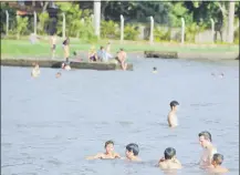  ??  ?? Pese a las advertenci­as de que el lago Ypacaraí no es apto para bañistas, siempre hay visitantes.