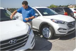  ??  ?? Jason Williams sets keys up with new Hyundais at the new Mountain View Hyundai on Wednesday.