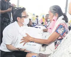  ?? PHOTO COURTESY OF PTT PLC ?? PTT Plc president and CEO, Auttapol Rerkpiboon, offers basic necessitie­s to a woman yesterday as he visits residents affected by the gas blast.