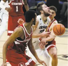  ?? David Zalubowski / Associated Press ?? Colorado’s Lucas Siewert (center) is fouled as he tries to shoot between Stanford’s Trevor Stanback (left) and Reid Travis.