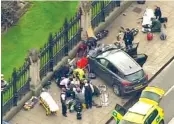  ?? THE ASSOCIATED PRESS ?? In this image taken from video, police officers gather around a car adjacent to the houses of Parliament in London on Wednesday after the sitting House of Commons was suspended when witnesses reported hearing gunfire outside.