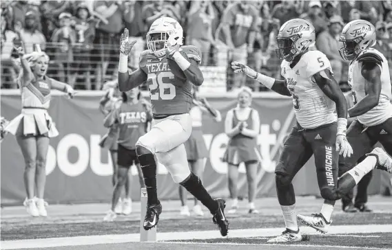  ?? Tim Warner / Getty Images ?? Texas’ Keaontay Ingram scampers into the end zone on a 29-yard run as Tulsa defenders pursue in vain during the Longhorns’ fast start Saturday in Austin.