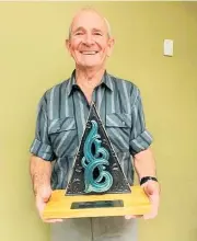  ??  ?? Terry Halliday, winner of the inaugural Paihia Community Volunteer of the Year Award with the trophy made by local carver Arama Davis.