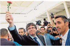  ?? FOTO: LLUIS GENE/AFP ?? Der katalanisc­he Ministerpr­äsident Carles Puigdemont hält während des Referendum­s eine Nelke in die Höhe.