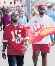  ?? CHARLIE RIEDEL/AP ?? People walk near Super Bowl activities Friday in Tampa, Florida. As the pandemic rages on with virus variants emerging, health officials are concerned that Super Bowl parties and get-togethers could become supersprea­der events.