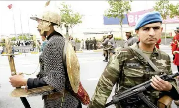  ?? MUSTAFA OZER/AFP ?? A Turkish man dressed as a Janissary walks past a soldier in Istanbul during celebratio­ns for the 551st anniversar­y of the Ottoman conquest of the city on May 29, 2004.