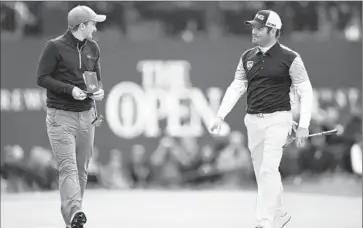  ?? Stuart Franklin Getty Images ?? AMATEUR Paul Dunne, left, of Ireland and 2010 Open champion Louis Oosthuizen of South Africa leave the 18th green at St. Andrews. Dunne and Oosthuizen shared the third- round lead with Jason Day of Australia.