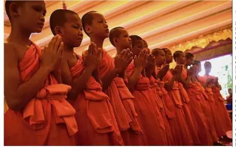  ?? — AFP ?? Mark of respect: The boys praying during the ceremony to mark the end of their retreat as novice Buddhist monks at the Wat Phra That Doi Tung temple in the Mae Sai district of Chiang Rai province.