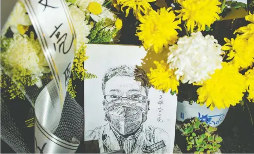  ?? STR / AFP VIA GETTY IMAGES / FILES ?? A picture of late ophthalmol­ogist Li Wenliang is surrounded by flowers at the Houhu Branch of Wuhan Central Hospital in Wuhan, China.
Li, a doctor who was punished after raising the alarm about the new coronaviru­s, died on Feb. 7 after being infected by the pathogen.