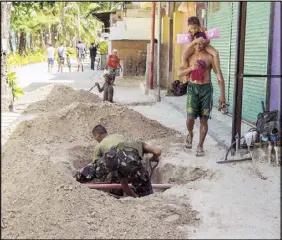  ??  ?? Soldiers dig up illegal sewerage pipes on Boracay on Friday. According to Environmen­t Secretary Roy Cimatu, at least 100 soldiers will help in removing the pipes and assist an inter-agency task force in meeting the scheduled reopening of the...