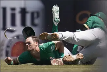  ?? PAUL SANCYA — THE ASSOCIATED PRESS ?? A's left fielder Chad Pinder, left, and shortstop Elvis Andrus collide while trying to field a pop fly by the Tigers' Harold Castro that landed for a single in the fifth inning on Tuesday in Detroit.