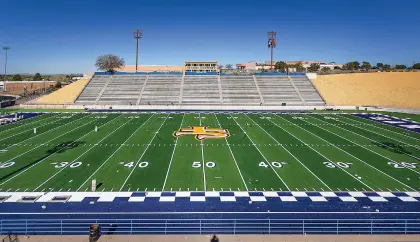  ?? JIM WEBER/THE NEW MEXICAN ?? Contractor­s with Hellas Constructi­on of Austin, Texas, work Tuesday to put some finishing touches on new turf at Santa Fe High’s Ivan Head Stadium. Santa Fe High head football coach Andrew Martinez said he likes the feel of the new turf, which has a much softer cushion to it, and the team should start summer workouts on the turf after graduation.