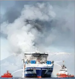  ?? GUGLIELMO MANGIAPANE / REUTERS ?? Smoke rises from the Italian-flagged Euroferry Olympia on Feb 19 after the vessel caught fire off Corfu the day before. A survivor was rescued on Feb 20 morning from the stern of the ferry, with 11 people still missing. The ship had been sailing from Greece to Italy.