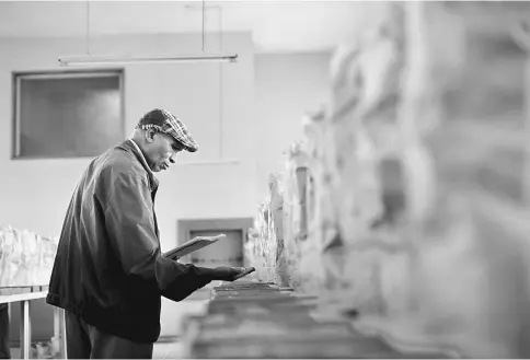  ??  ?? A coffee buyer inspects Kenyan coffee beans which he intends to buy for export in the samples room at the Nairobi Coffee Exchange (NCE) in Nairobi, Kenya, on May 23. — WPBloomber­g photos