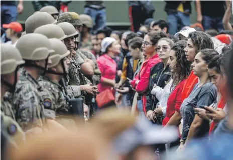  ?? AFP ?? Women and Lebanese soldiers face off in Zouk Mosbeh yesterday, the seventh day of protests against taxes and corruption