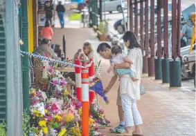  ??  ?? Residents lay flowers at the scene.