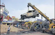  ?? SONU MEHTA/HT ?? A crane lifts a charred vehicle in Chand Bagh days after communal violence and arson in north-east Delhi.