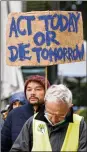  ?? FRANCOIS WALSCHAERT­S/AP ?? A climate activist holds a sign during a demonstrat­ion outside of an EU summit in Brussels, Thursday.