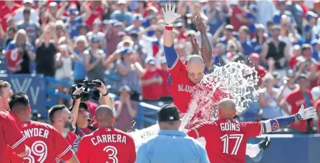  ?? TOM SZCZERBOWS­KI/GETTY IMAGES ?? Toronto Blue Jays players celebrate with teammate Steve Pearce as he reaches home plate after hitting his second walk-off grand slam in five days. Sunday’s blast capped a seven-run bottom of the ninth as Toronto rallied to beat the Los Angeles Angels...