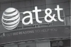  ??  ?? BELOW: The AT&T logo is positioned above a retail store in New York City.