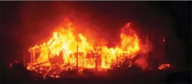  ?? MIKE ELIASON — SANTA BARBARA COUNTY FIRE DEPARTMENT VIA AP ?? In this Sunday photo released by Santa Barbara County Fire Department, a home burns early Sunday morning off Gobernador Canyon Road in Carpinteri­a A flare-up on the western edge of Southern California’s largest and most destructiv­e wildfire sent...