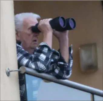  ??  ?? A Duncannon resident using his binoculars to get a closer look at the sunken Aztec boat being lifted.