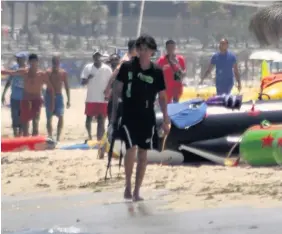  ??  ?? Tunisian gunman Seifeddine Rezgui walking along the beach with his rifle
