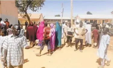  ?? AP ?? People gather inside the Government Science Secondary School in Kankara, Nigeria, on Saturday. Katsina State police spokesman Gambo Isah said the school was attacked Friday night by a large group of bandits.