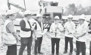  ?? ?? PANTAU: Uggah disertai (dari kiri) wakil kontraktor Chew, Richard, Jason dan Cassidy di tapak projek.