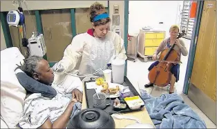  ?? AP PHOTO ?? Cellist Martha Vance plays for a patient at Medstar Georgetown University Hospital in Washington D.C. Musicians and dancers are part of the Georgetown Lombardi Comprehens­ive Cancer Center’s arts and humanities program