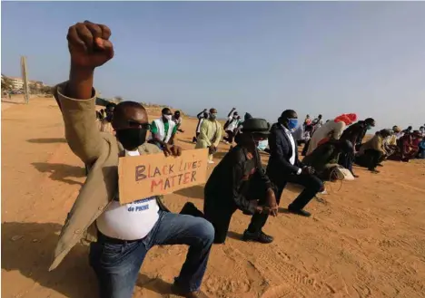  ?? (ZOHRA BENSEMRA/REUTERS) ?? Des Sénégalais mettent un genou à terre lors d’une manifestat­ion «Black Lives Matter» à Dakar.