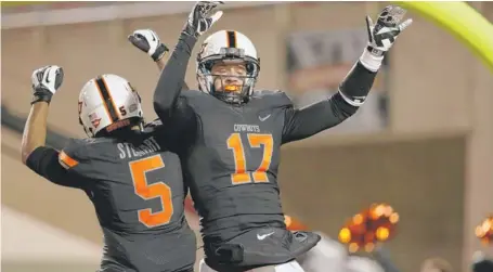  ?? | SUE OGROCKI/AP ?? Oklahoma State wide receiver Charlie Moore (17) celebrates a touchdown against Baylor with teammate Josh Stewart in the second quarter.